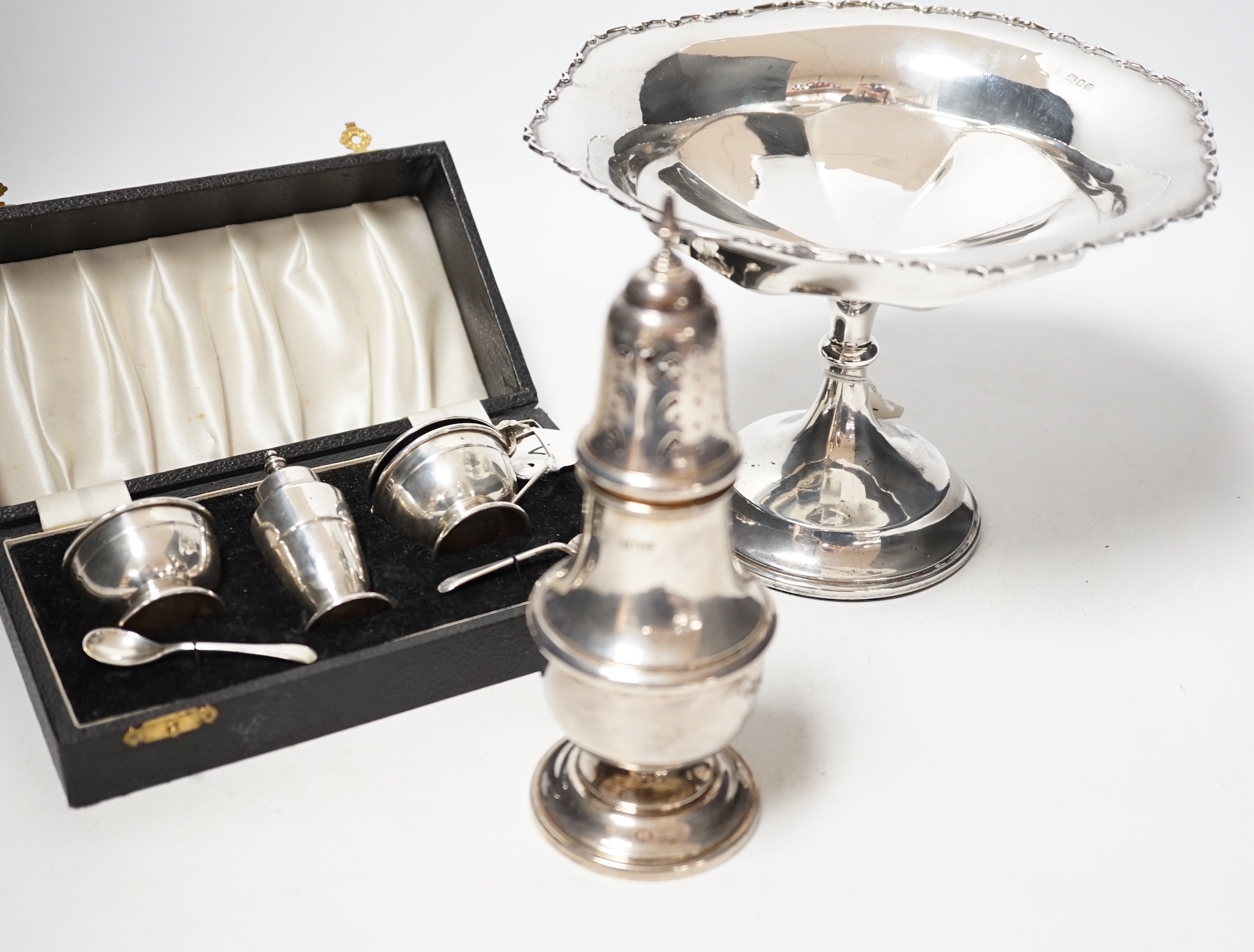 A modern silver baluster sugar caster, Birmingham, 1972, 17.5cm, a cased silver three piece condiment set an a George V silver tazza, weighted.